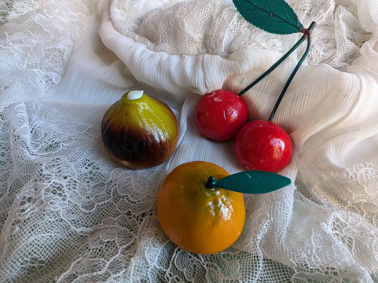 Frutta realistica di pasta di mandorla: fichi, ciliegie e arance